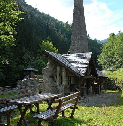 Wentsteinhammer, © Naturpark NÖ Eisenwurzen Historische Schmiede mit Kamin im Wald, Holztische im Vordergrund.