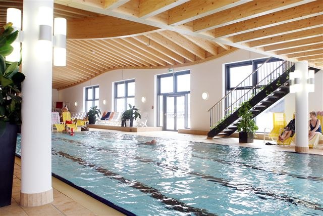 Ybbstal brine bath, © Ybbstaler Solebad Interior view of a swimming pool with wooden ceiling and large windows.
