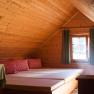 Bed store, © most-media.at Cozy attic room with wood paneling, beds and checkered pillows.