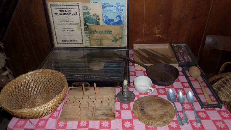 Farmhouse museum Ablass, © Farmhouse-Museum "Ablaß" Table with old kitchen utensils and zither school books.