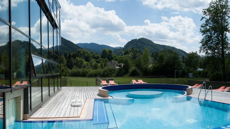 Göstling_Bad_Erlebnis-Außenbecken_27.06.2014_Rene_Jagersberger_A (36), © Rene Jagersberger Outdoor area of the Ybbstaler Solebad with pool and sun loungers, surrounded by green hills and trees.