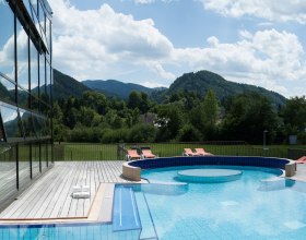 Göstling_Bad_Erlebnis-Außenbecken_27.06.2014_Rene_Jagersberger_A (36), © Rene Jagersberger Outdoor area of the Ybbstaler Solebad with pool and sun loungers, surrounded by green hills and trees.