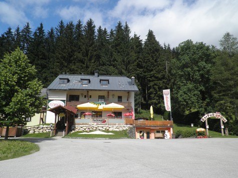 Pizza-Restaurant Fuchswald, © ÖTV Ein Restaurant mit Terrasse und Sonnenschirmen vor einem Wald.