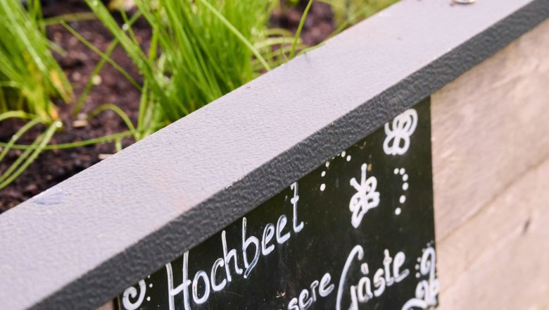 Kräuterhochbeet für die Urlaubsgäste, © grasberger Ein Hochbeet mit Kräutern und einem Schild mit der Aufschrift 'Hochbeet für unsere Gäste'.