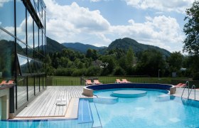 Göstling_Bad_Erlebnis-Außenbecken_27.06.2014_Rene_Jagersberger_A (36), © Rene Jagersberger Outdoor area of the Ybbstaler Solebad with pool and sun loungers, surrounded by green hills and trees.