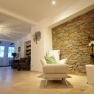 Maria Seesal fasting house, © zVg Fastenhaus Cozy room with stone wall, armchair and decorative lamp.
