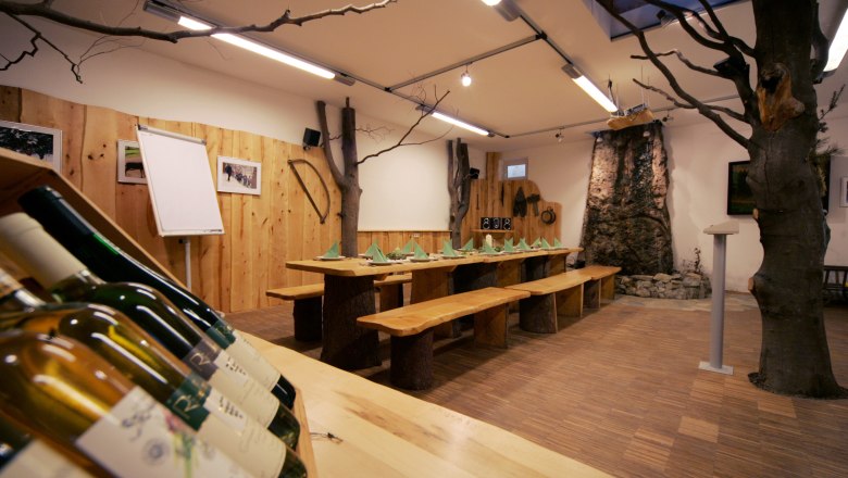 Nature park house in the Buchenberg adventure park, © weinfranz.at Cozy nature park house with wooden table, a tree in the room and warm wooden interior.