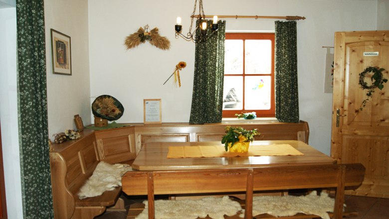 Common room, © zVg Cozy lounge with wooden furniture, table, corner bench and decorations on the wall.