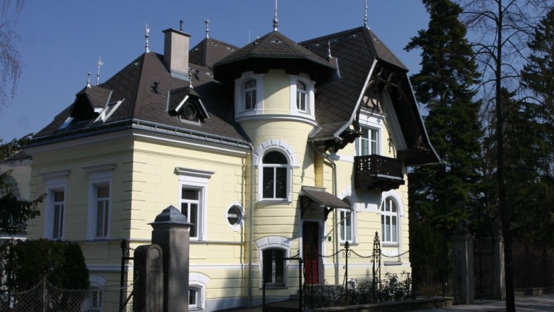 Aussenansicht, © Villa Nova Außenansicht einer gelben Villa mit Türmchen und Balkon.