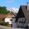 Ein Ferienhaus mit Blumen und Berg im Hintergrund.