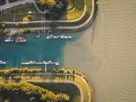Luftaufnahme der M&uuml;ndung der Erlauf in die Donau, daneben der Erlauftalradweg ums&auml;umt von Gr&uuml;nfl&auml;chen