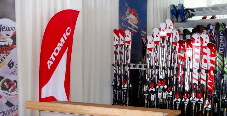 Skiverleih mit Atomic-Skiern und Werbebanner.