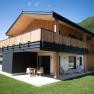 Modern wooden architecture of a two-storey building with balcony and terrace, surrounded by green landscape.