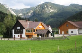 Ein Geb&auml;ude mit der Aufschrift 'Schistadl' vor einer Berglandschaft.