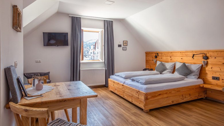 Cozy bedroom with wooden furniture and sloping ceiling.