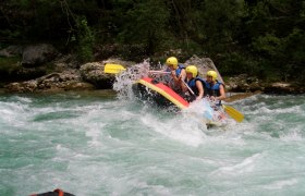 Gruppe von Menschen beim Rafting auf einem wilden Fluss.