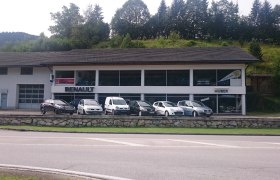 Autohaus Huber with Renault logo and several cars in front of it.