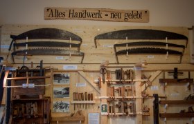 Exhibition of old hand tools on a wooden wall with the sign 'Old craft - new life'.