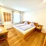 A cozy bedroom with wooden furniture, a double bed, and a bunk bed.