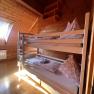 Ein gem&uuml;tliches Schlafzimmer mit Holzverkleidung und einem Etagenbett unter einem Dachfenster.