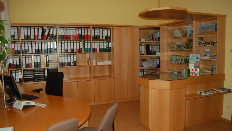 Interior view of an office with wooden shelves, file folders and a reception desk.