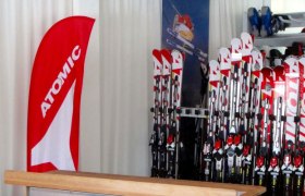 Ski rental with Atomic skis and advertising banner.