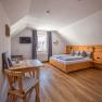 Cozy bedroom with wooden furniture and sloping ceiling.