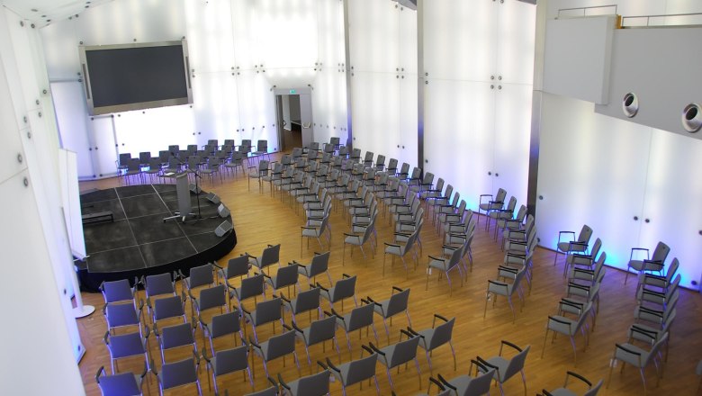 Moderner Konferenzsaal mit Stuhlreihen und B&uuml;hne im Schloss Rothschild, Kristallsaal.