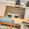 Modernes Studio-Apartment mit Bett, K&uuml;che und stilvoller Beleuchtung.