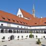 Innenhof der Kartause Gaming mit Arkaden und rotem Ziegeldach.