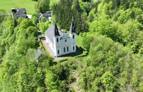 Aerial view of the Maria Seesal pilgrimage church, surrounded by green trees and forests.
