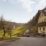 The Glockriegl family farm&mdash;a yellow farmhouse with a balcony&mdash;is situated in a green, rolling landscape.