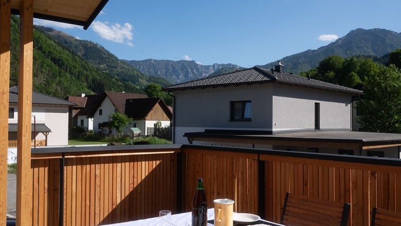 Ein gedeckter Tisch auf einer Terrasse mit Bergblick.