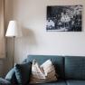 Wohnzimmer mit Sofa, Stehlampe und Bild an der Wand.