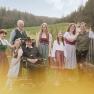 Eine Familie in traditioneller Tracht posiert im Freien vor einer l&auml;ndlichen Kulisse.