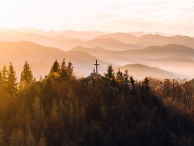 Die sanften H&uuml;gel des Mostviertels erstrahlen im warmen Licht des Herbstes, w&auml;hrend die B&auml;ume in leuchtenden Farben leuchten. Ein Kreuz auf dem Gipfel l&auml;dt Wanderer ein, die atemberaubende Aussicht auf die umliegenden Berge und T&auml;ler zu genie&szlig;en. Hier, wo die Natur in voller Pracht erbl&uuml;ht, findet jeder Besucher einen Ort der Ruhe und Inspiration.