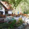 Outdoor area of the Schindlh&uuml;tte with tables and chairs in the green.