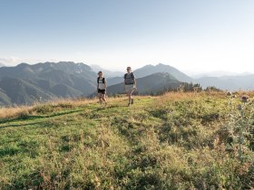 Die sanften H&uuml;gel der Ybbstaler Alpen laden zu einem unvergesslichen Wanderabenteuer ein. Zwei Wanderer genie&szlig;en die frische Bergluft und die atemberaubende Aussicht auf die umliegenden Gipfel, w&auml;hrend sie durch die bl&uuml;henden Wiesen schreiten. Hier, wo die Natur in voller Pracht erbl&uuml;ht, wird jeder Schritt zu einem Erlebnis.