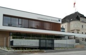 Modern building of the state hospital with glass fa&ccedil;ade and older extension.