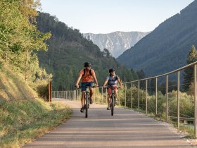 Two cyclists glide relaxed along the Ybbstal cycle path, surrounded by the majestic backdrop of the Ybbstal Alps. The rolling hills and clear blue skies create an inviting atmosphere for adventure seekers and nature lovers. Here, summer in the mountains becomes an unforgettable experience.