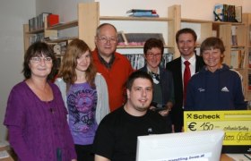 Group of people in a library with a check for 150 euros.