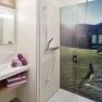 Modernes Badezimmer mit Dusche und Landschaftsbild auf der Duschwand.