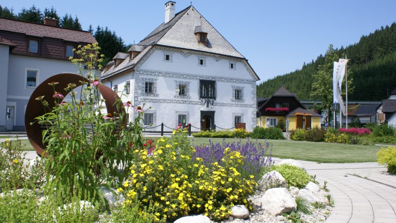 Historic building with flower bed in the foreground.